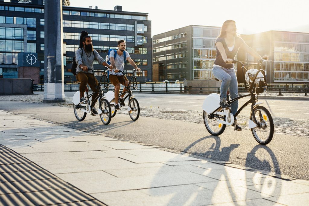 Three people cycling in city